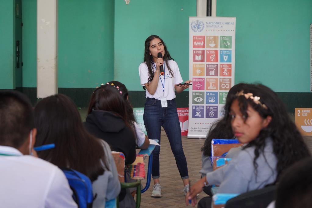 Joven con camiseta blanca explica los ODS estudiantes en Guatemala