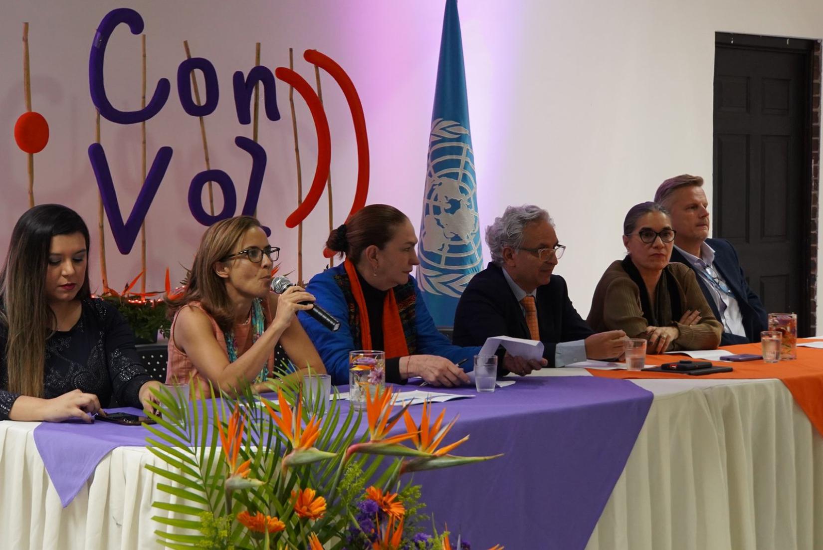 Representantes de agencias de la ONU, junto a María Alejandra Grotewold (participante del diseño de la campaña)en una mesa al frente de personas con discapacidad explican su compromiso con los derechos de las personas, particularmente  con discapacidad