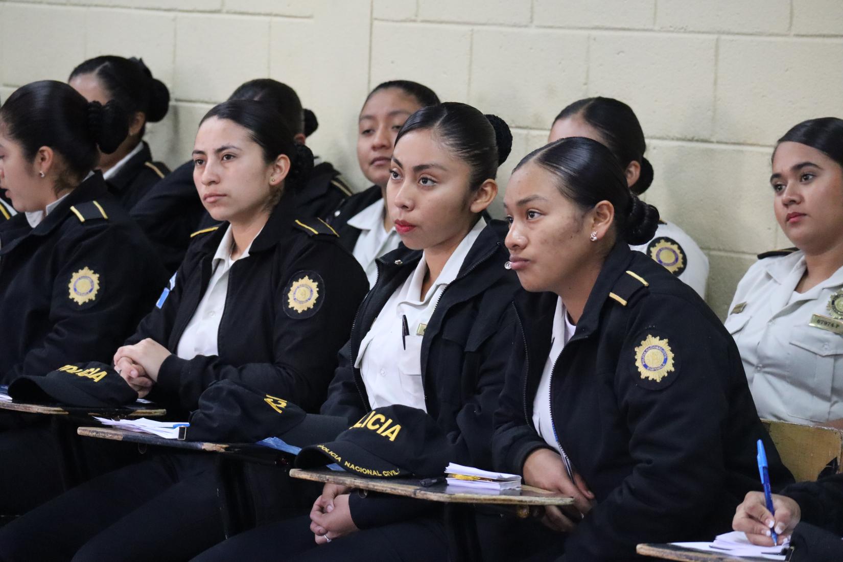 Mujeres policías sentadas atendiendo la clase
