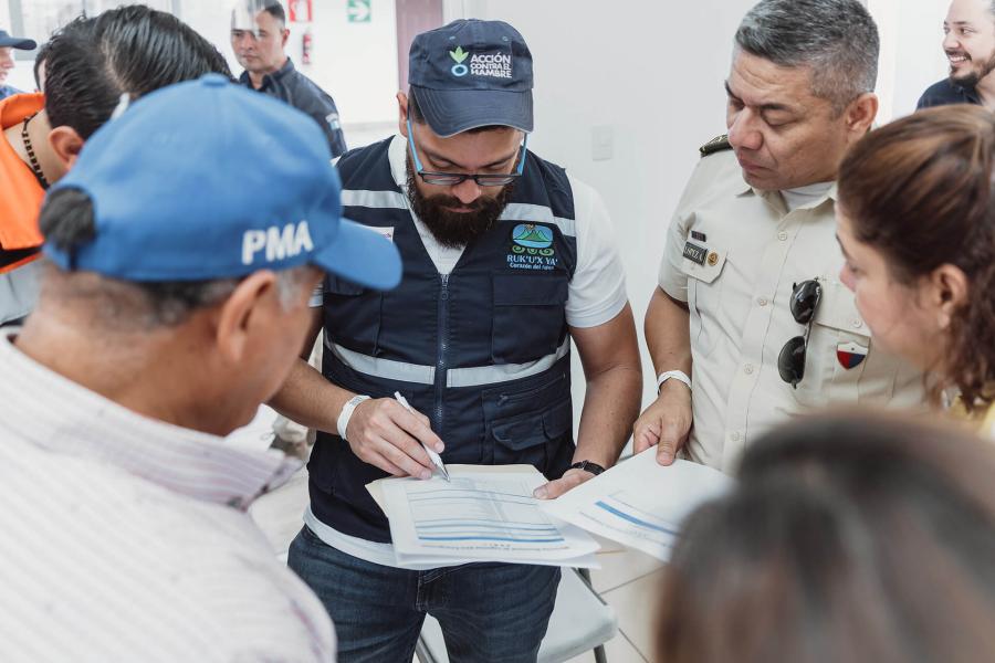 Un participante escribe en un formulario, los demás le hacen rueda de pie para observar el ejercicio