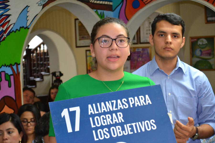 Una joven sostiene el ícono del ODS 17 sobre alianzas para lograr los objetivo, en una actividad de capacitación